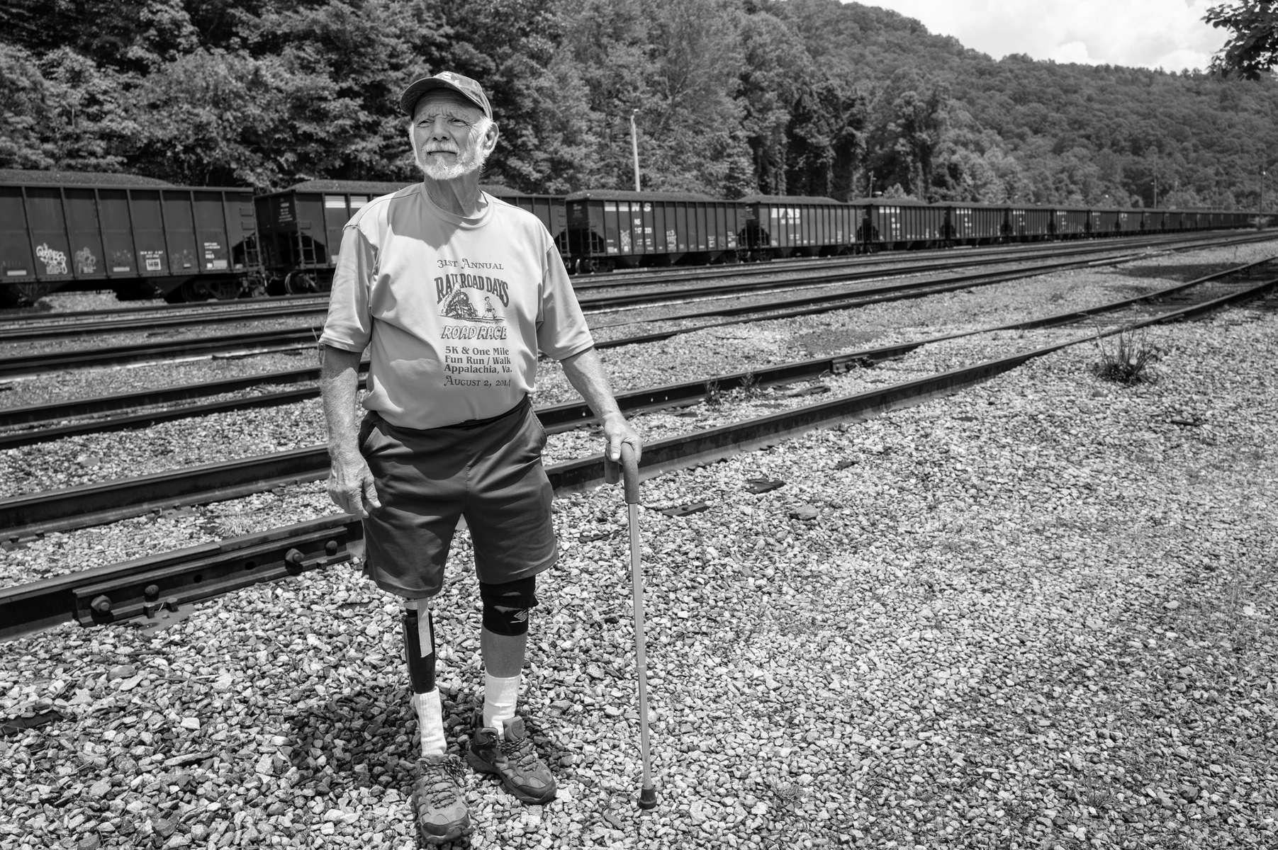 Former coal miner Bud Sampson stands by railroad tracks behind his home in Andover, VA. Bud did not lose his leg in a mine accident, but rather when he was hit head-on in his car by a woman driver having a seizure two years ago. The injury has merely slowed Bud down a bit, as he remains active with his grandchildren and with his local church. Outgoing and upbeat more than almost anyone i’ve ever known, Bud is buoyed by his strong family ties, including his wife Louise, and by his rock-strong Christian faith. 