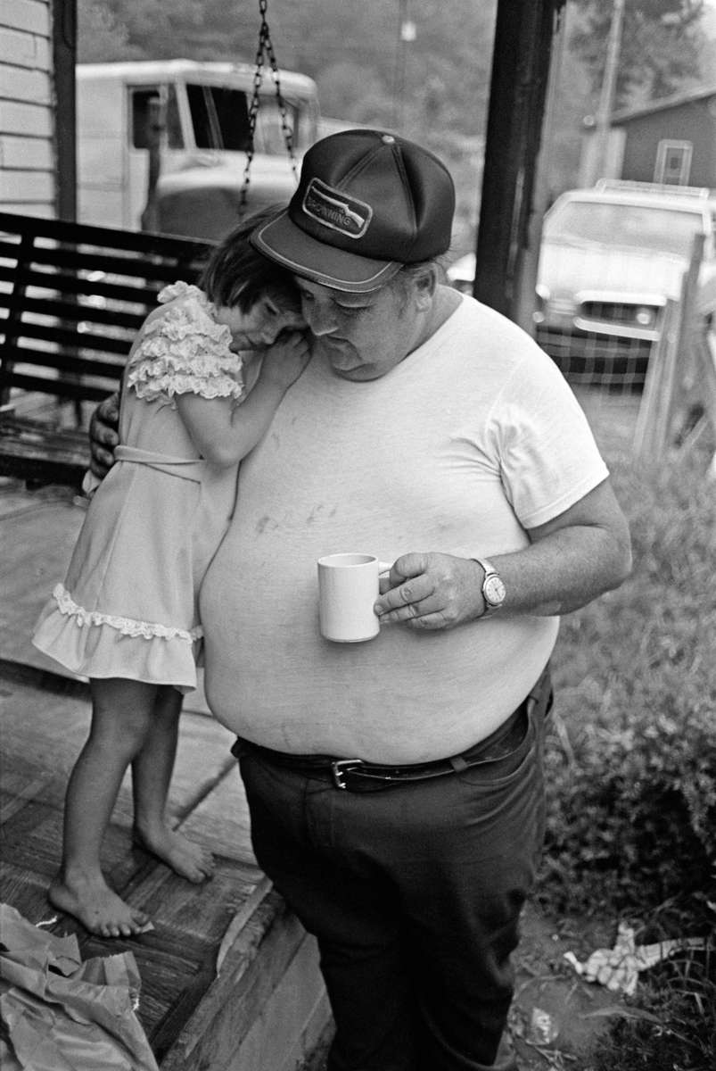 A father comforts his young daughter on his front porch, somewhere in Coal Country, Kentucky. Jon Chase photo