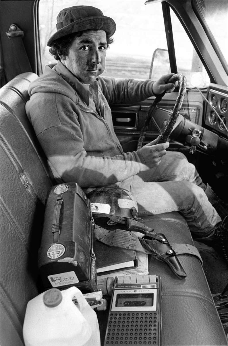 Doug Shelton, a non-union supervisor drives to check on the condition of a mine during the national bituminous coal strike of 1978 near Norton, VA. He has a pistol on the seat and a rifle below it, while he keeps a close watch on the surrounding steep hillsides for anyone who might shoot at his truck thinking he is intending to work during the strike. He also explained that long-standing personal feuds are often played out and settled under the guise of union-coal company violence. Jon Chase photo