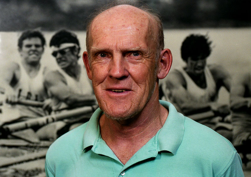 © 2010 Harvard University. Harry  Parker, in his 40th year as Harvard men's crew coach, stands by a photo of the 1974 heavyweight crew that went undefeated for 4 consecutive years.