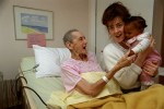 Rita, who worked as a nurse for 50 years, greets the young child of an AIDS patient down the hall.