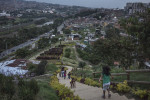 Residents walk the pathway to the top of the {quote}hill{quote}, the area of a new garden. Since 2012, the city of Medellin began an innovative project in the neighbourhood of Moravia to transform the city’s main garbage dump into a sustainable garden where 50 thousands residents lived. They did this by planting specific kinds of bacteria and plants to absorb gaseous toxins from the garbage. However to implement the project, the city relocated about 17,000 people Some families moved into high-rise public housing in the community, but others were moved to a remote area of the city, about an hour from their jobs and former neighbourhood.