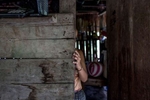 EL ESTOR, GUATEMALA. February 12, 2018 – An indigenous Maya Q'eqchi woman at home in a community in the Polochic Valley, Guatemala. Her family have received threats from their neighbors because her father works for a banana and palm oil company, which many do not agree. However, his employment has helped the family, they have a larger home, and small plot of land, and better living conditions than most in their community.