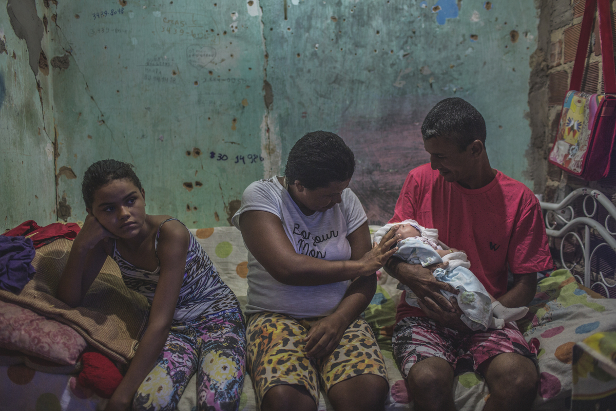 JANUARY 9, 2016 -- Maria Rodrigues, 29, and her husband, Romero Perreira, 39, and their daughter, Veronica, 10, left, visit with Duda, the baby's biological parents who abandoned Duda at the maternity hospital because she couldn't care for their daughter, in their tiny one-room home, in Olinda. Both Maria and her husband, who are recyclers, suffer from a mental disorder and alcoholism. 