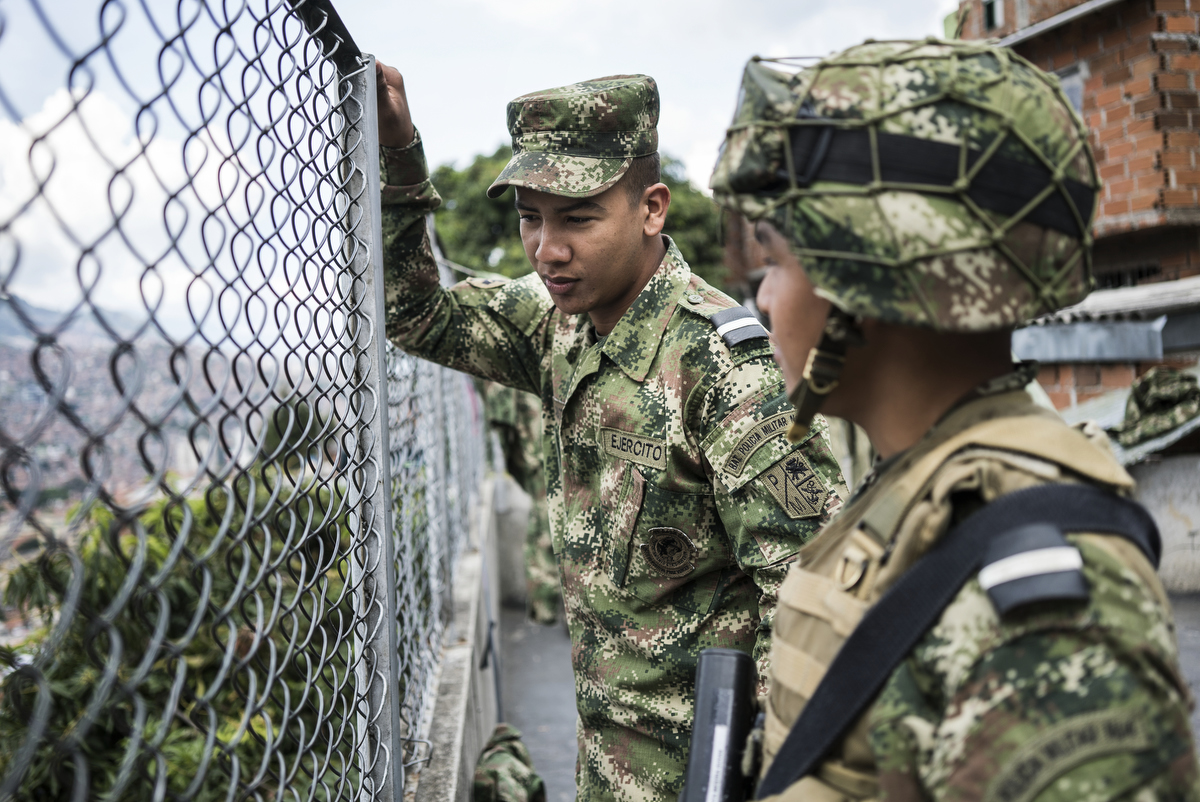 An army unit stationed in Comuna 13, the most dangerous district in Medellin, Colombia. There are eight bases with 140 soldiers in the district. In 2006, the city built a public library, a new school, public green spaces, and improved access to transportation through a cable car line and escalators connecting the neighbourhoods to the metro and the city. 