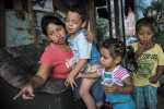 Marta Chica Lopez, 27, points to a dead chick, near the chicken coop, to her son, Juan Esteban, 6, left, and daughter Luciana, 2, center, and nephew, right, at their home in the neighbourhood of Moravia, a former garbage dump. Marta grew up in this two-story house that her grandfather built 24 years ago, and made of a patchwork of wood scraps. Since 2012, the city of Medellin began an innovative project in Moravia to transform the city’s main garbage dump into a sustainable garden where 50 thousands residents lived. However to implement the project, the city relocated about 14,000 families. Some families moved into high-rise public housing in the community, but others were moved to a remote area of the city, about an hour from their jobs and former neighbourhood. Marta's family fought several rounds of evictions to stay in the neighbourhood.