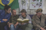 Retired sheriff Alberto Augusto, 72, center, reads a book, called Orvil (which is spelled {quote}book{quote} in Portuguese backwards), with his son, Alberto Augusto Filho, 60, (right), Joyce Torres, 22, (left) and Sergio Veber, 51, (center left) - members of the of the Brazilian Interventionist Resistence Movement (MBRI).The book is the military's version to counter the creation of the National Commission of Truth, which investigated prisons, tortures and assassinations by the military during the dictatorship. 