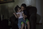 Wilder Gonzalez, 10, holds his baby sister, Katherine, at a family home shelter in a city program called, {quote}Madres Acojientes,{quote} in Medellin, Colombia. 