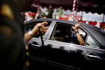Former Army General Soenarko holds up a {quote}number one{quote} finger out the car window as he departs his post after a general handover event in Banda Aceh, Indonesia, on Nov. 20, 2009. Since the signing of Helsinki peace accord in 2005 that ended the longest conflict in Indonesia between the Free Aceh Movement and Indonesian government, the country has pulled out more then 20,000 troops from the province. The army base in Banda Aceh currently has about 15,000 soldiers.
