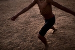 Sobradinho Reservoir, Brazil. Monday, July 20, 2015. A youth plays soccer on a dirt pitch at dusk, near the Sobradinho Reservoir, Brazil. 