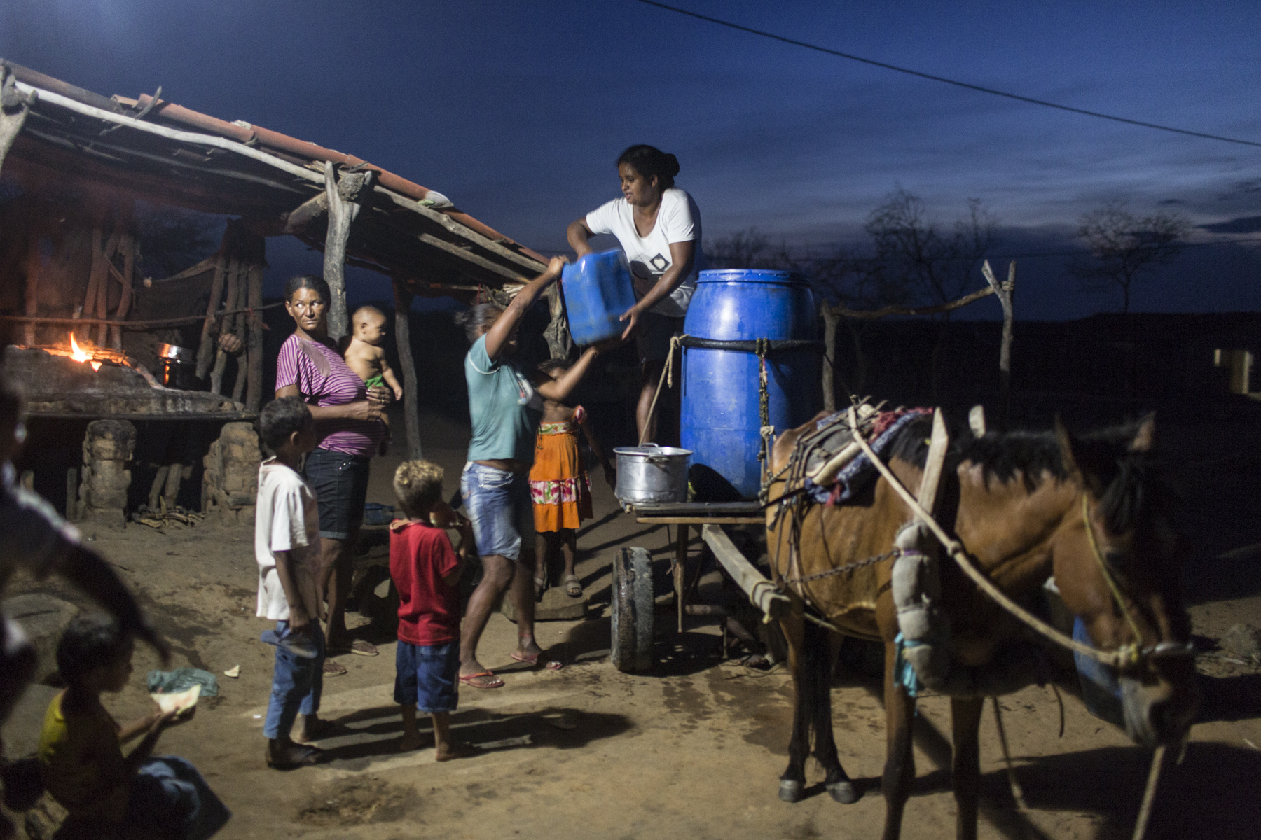 Campo Alegre de Lourdes, Brazil. Saturday, Nov. 14, 2015.A neighbor delivers potable water to Severiana and Pedro’s home in a homestead near Campo Alegre de Lourdes, in Bahia state. Although farming families receive a national anti-poverty cash welfare program, Bolsa Familia, they still suffer from chronic malnutrition, food shortages and limited access to water. The big blue barrel costs $10 Reals, or $2.50 USD.