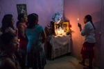 Campo Alegre de Lourdes, Bahia. Tuesday, Feb. 9, 2016.Dona Maria de Lourdes da Silva, 75, right, sings prayer songs and gives thanks for the return of her figurines, Saint Antonio (St. Anthony is the Patron Saint of Lost Things and Lost Souls) and Sagrado Coraçao de Jesus (Sacred Heart of Jesus which represents divine love), with her neighbors at her home, near Campo Alegre de Lourdes, in the state of Bahia. During intense droughts, families engage in a unique ritual. They 'steal' one another’s saint figurine, called {quote}Rouba do Santo,{quote} or rob the saint. The return of the Saint to the owner is called {quote}Levada do Santo,{quote} or return the saint. Families practice this ritual to invoke rain to fall. When a Saint goes missing, the power of faith by the owner of the Saint prays immensely for the rain to come. When the rains come, the Saint is then returned. If the rain doesn’t come, the Saint remains missing.Seven days after Dona Maria’s Saint went missing, the rains came and stayed for a month. It was the first significant rain in about six years.