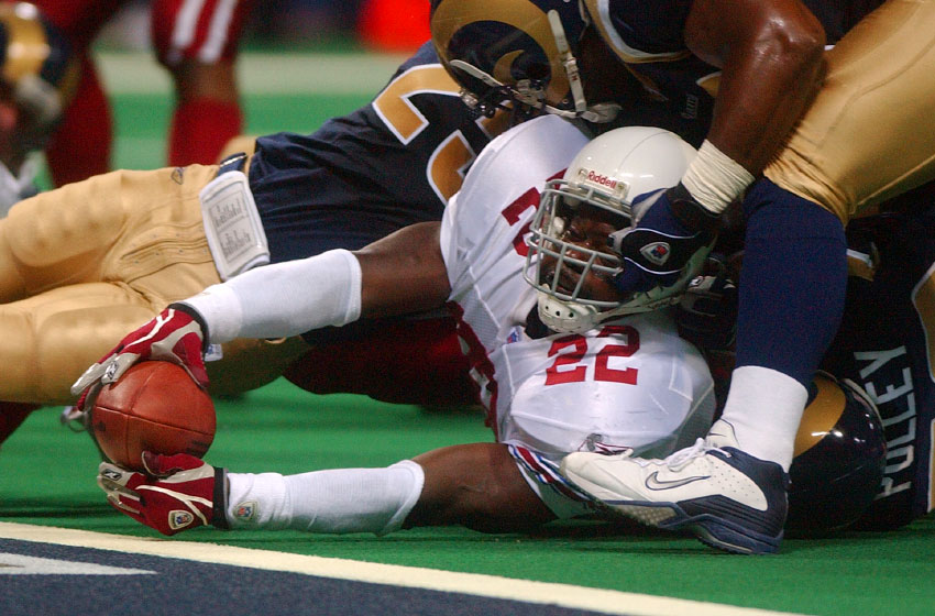 The St. Louis Rams' Jamie Duncan grabs the facemask of Emmitt Smith as Smith 