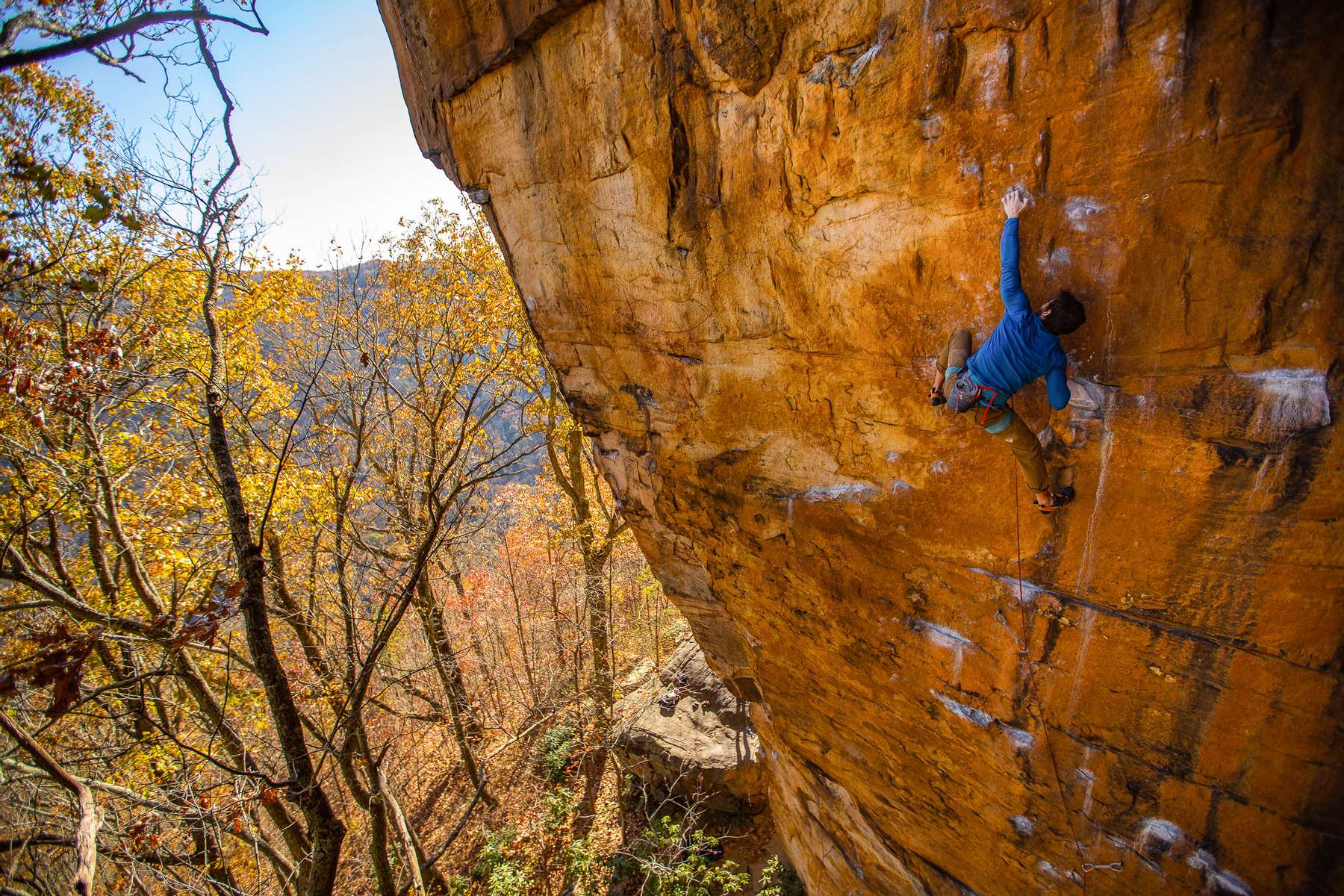 Men and women rock climbing at the new river gorge in West Virginia in the fall.