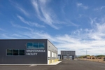 Exterior image of public works facility buildings in Hyrum, UT.The sky is blue and suuny and the building are utilitarian, grey and square in shape.