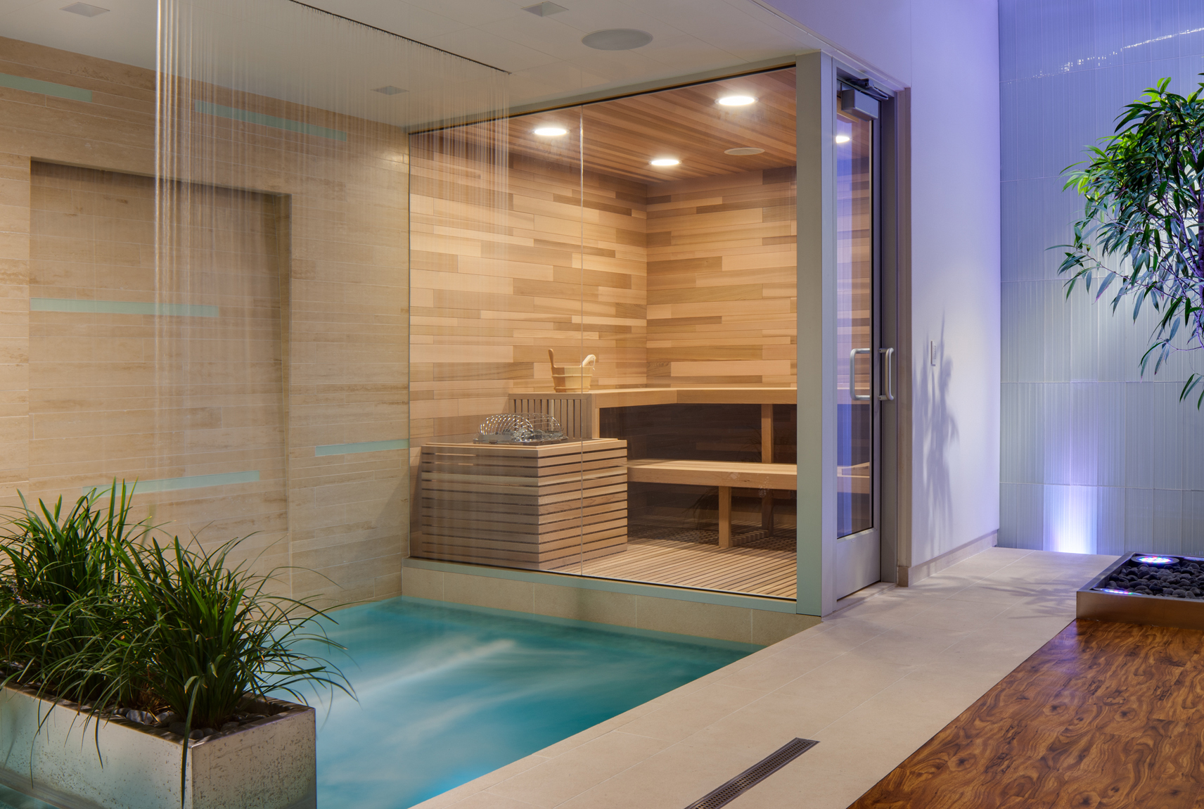 Spa room featuring cascading water, purple LED lighting and a wood clad sauna.