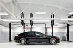 Interior high key, view of  black  Porsche Panamera in a service bay with white and gray walls.  