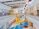  View down curved main hall of middle school with students in motion. MHTN Architects / Hogan & AssociatesArchitectural Photography by Paul Richer / RICHER IMAGES