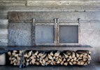 This is a photograph of a custom built firepalce in a mountain rustic home near Park City, UT. The fireplace is encased in distessed steel and surrounded by a wall clad in reclaimed timber.