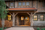 This view of the main entrance to a Private Residence near Park City, UT. for Line 8 Design.shows warm glowing windows and pleanty of rustic and reclaimed timber.