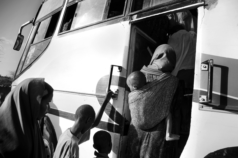 New Somali arrivals are loaded onto a bus at the reception center and driven to the registration center where they are photographed and Id's.