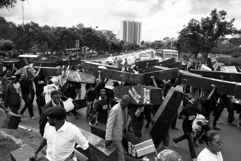 Hundreds of Kenyan's gathered at Uhuru (Freedom) Park and marched through City Center carrying 221 coffins to Parliament. The demonstrators were protesting Parliaments send-off package, which included a hefty retirement bonus, a state funeral and bodyguards. The coffins were burned in front of Parliament to signify the end of one era and the birth of another. The “mock funeral” was seen as an appropriate gesture as there is no more room for Kenyan's to bury their dead in Lang'ata Cemetery. Peaceful protestors carried coffins reading, “state burial” and “ballot revolution” through Nairobi’s city center on January 16th, 2013.