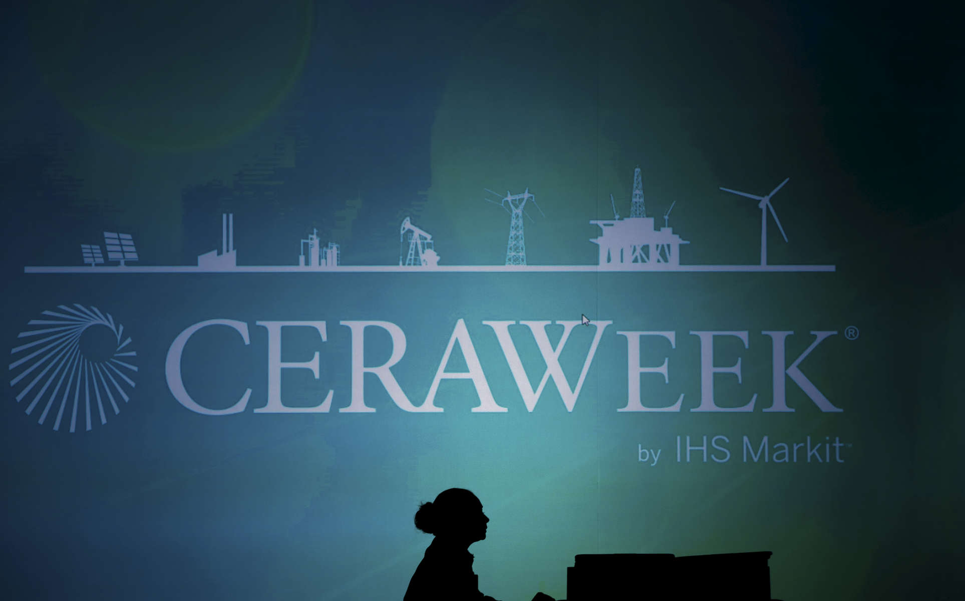An employee is silhouetted at CERAWEEK in Houston