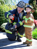 10/12/17-- FRAMINGHAM--Devin McKinney, 4, gets the run down from Framingham Fire Lt. Tom Rinoldo, before firefighters trained at 19 Lincoln St. Thursday morning. The house, which will be demolished in the next few weeks,  was made available for firefighters to train in by McCarthy, McKinney and Lawler Funeral Home.  Devin is funeral director Brian McKinney's son.  {quote}It's his Halloweeen costume but he wears it all the time,{quote} said his mom, Kerrin. {quote}This is a dream come true for him.{quote}  [Daily News and Wicked Local Staff Photo/Art Illman]