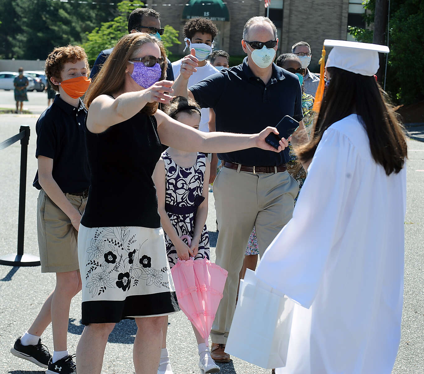 6/4/20-- FRAMINGHAM-- Saint Bridget School held a physically distanced outdoor graduation for 27 eighth grade graduates Thursday morning. Pictured, graduate Lucy DiMeo, of Ashland, is congratulated by mom Kim, dad Larry, brother Rudy, 13, and sister Caroline, 8, after the ceremony. [Daily News and Wicked Local Staff Photo/Art Illman]