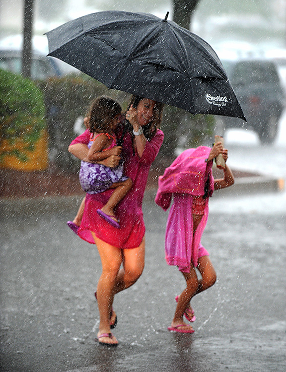 8/1/14-- FRAMINGHAM--  Michelle Marseglia with Alyssa, 3, and Avery, 6, of Ashland,  running through the rain at the Temple Street Stop and Shop parking lot Friday afternoon.Daily News Staff Photo/Art Illman