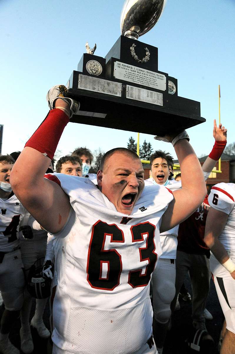 Wellesley High School football senior Anthony Messore hoists the Frederick Gorman Centennial Trophy for the nation’s oldest football rivalry, after defeating Needham at its 133rd meeting, 34-0, March 19, 2021.