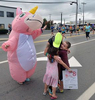 Runner Julie Dunbar of New York  hugs her neice and nephew, Jeffrey, 7, and Kate, 5,  Barlow, of Duxbury, with their mom, Marie Barlow in the unicorn costume, in Framingham, during the running of the 125th Boston Marathon, Oct. 11, 2021. 