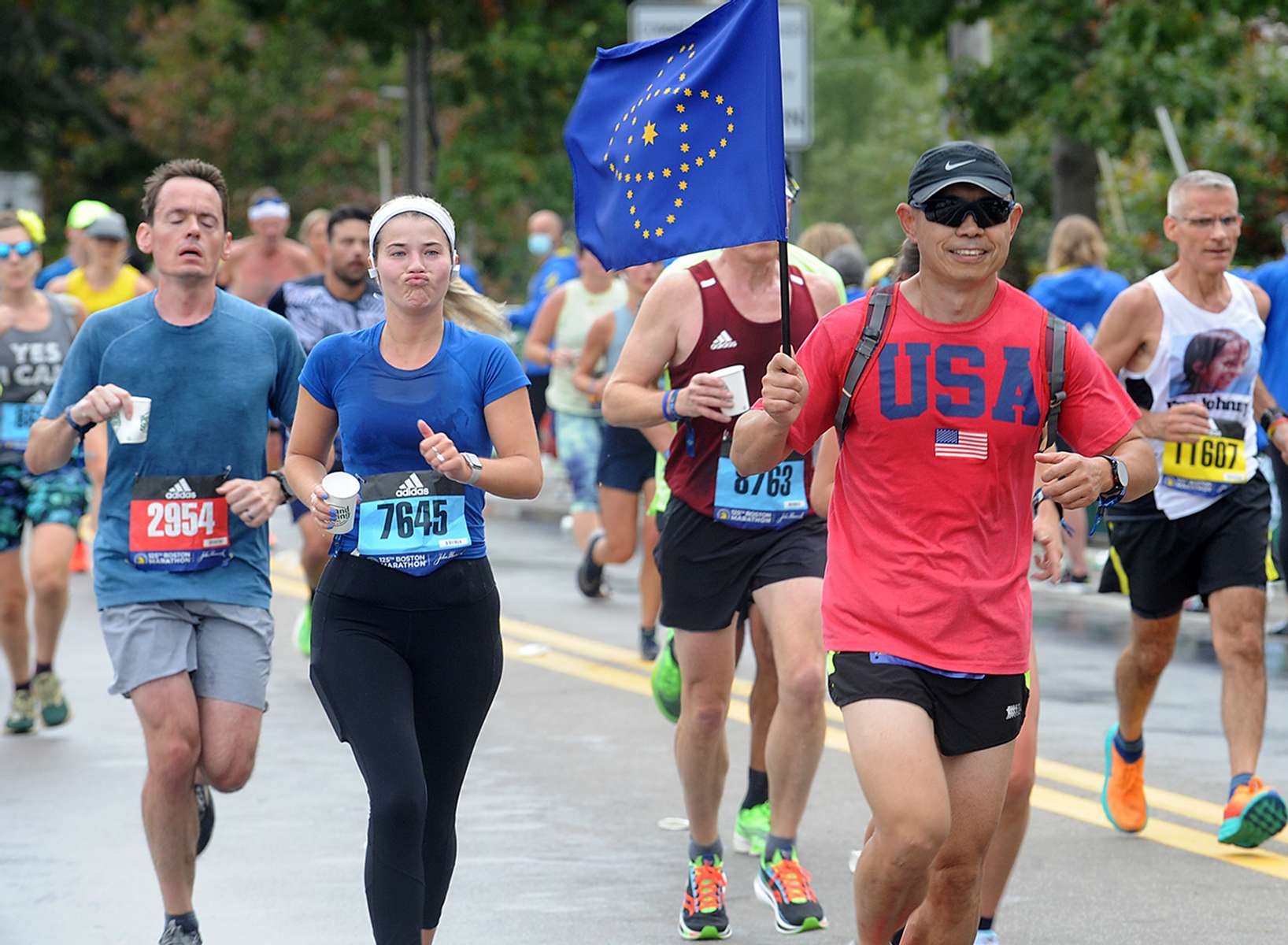 Runners in Framingham during the running of the 125th Boston Marathon, Oct. 11, 2021.
