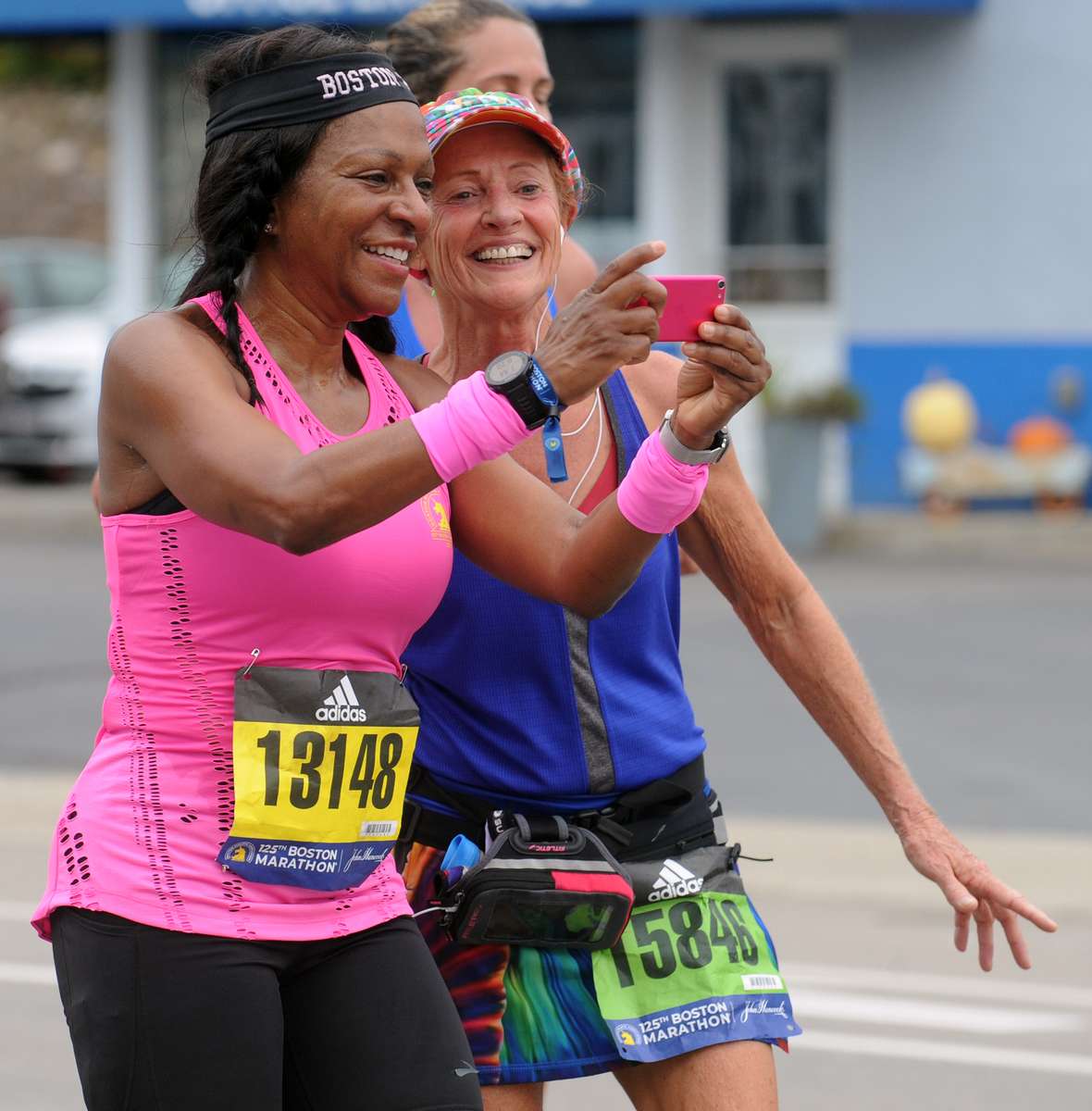 Sandra Tezino, left, and Trudy Regnier, both of Texas, left,  pause in Framingham for a selfie during the running of the 125th Boston Marathon, Oct. 11, 2021.