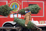 Ashland High School football player Patrick DesLauriers carries one of 700 Maine Christmas trees he and teammates unloaded  Nov. 27, 2020 for the Lions Club annual tree sale at 130 Pond St. which is open 3-6 p.m. Monday through Friday and 9 a.m. to 8 p.m. on weekends.