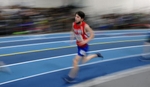 Natick High School sophomore Brian Arthur runs in the two mile at the Bay State Conference Championship at the Reggie Lewis Center, Feb. 9, 2022. The image is delibrately blurred with a long exposure. 