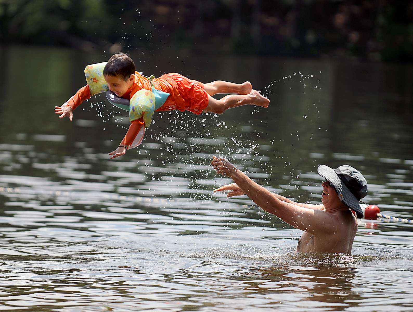 7/20/20-- ASHLAND-- Kaiden Waite, 4, is tossed into the water by dad Eric at the Ashland State Park Beach on Monday. [Daily News and Wicked Local Staff Photo/Art Illman]