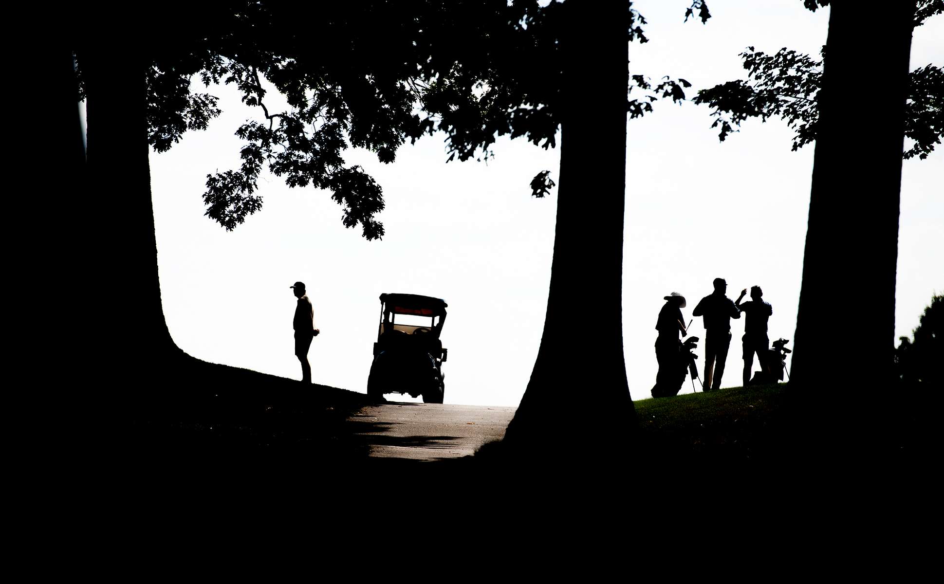 Golfers silhouetted at the Framingham Country Club on the opening day of the 116th Massachusetts Amateur Championship, July 8, 2024.