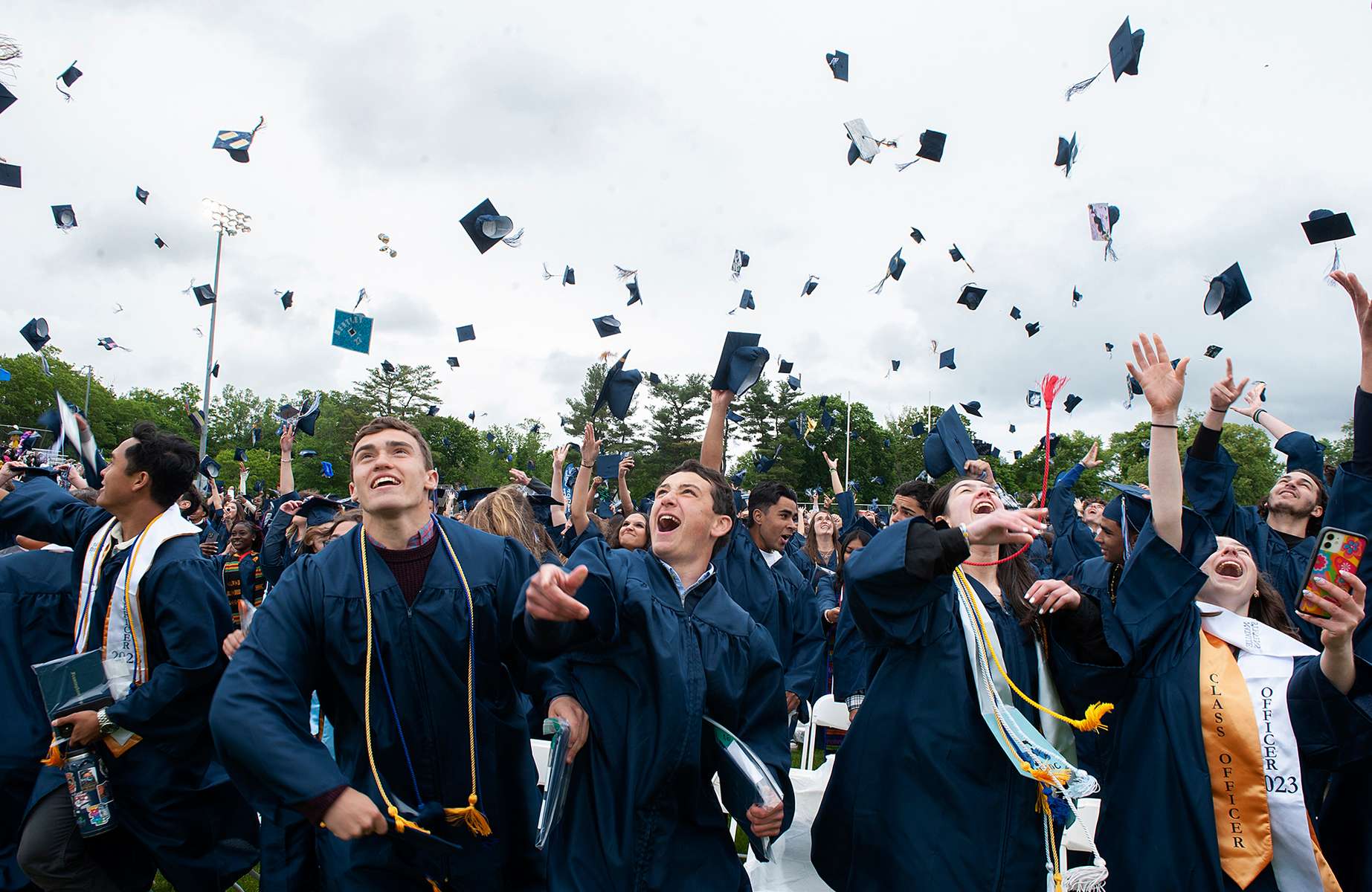 Framingham High School graduates, including Tyler Knox, Justin Nichols, Jenna Saxon and Natalie Stevens, toss their caps at the conclusion of the commencement ceremony at Bowditch Field,  June 4, 2023. 