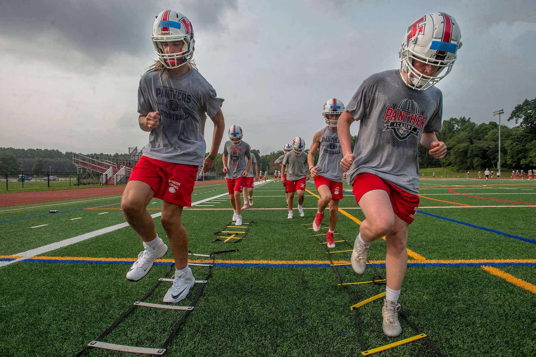 Holliston High School juniors Edward Daniels, left, and  Sean Klein run a ladder drill on the first day of football practice, Aug. 16, 2024. 