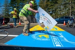 James Sawler of Road Safe Traffic lifts a stencil while painting the start line for the 127th running of the Boston Marathon on Rte. 135 in Hopkinton, April 11, 2023.