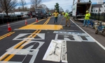 James Sawler of Road Safe Traffic applies the first coat of paint to the start line for the 127th running of the Boston Marathon on Rte. 135 in Hopkinton,  April 11, 2023.