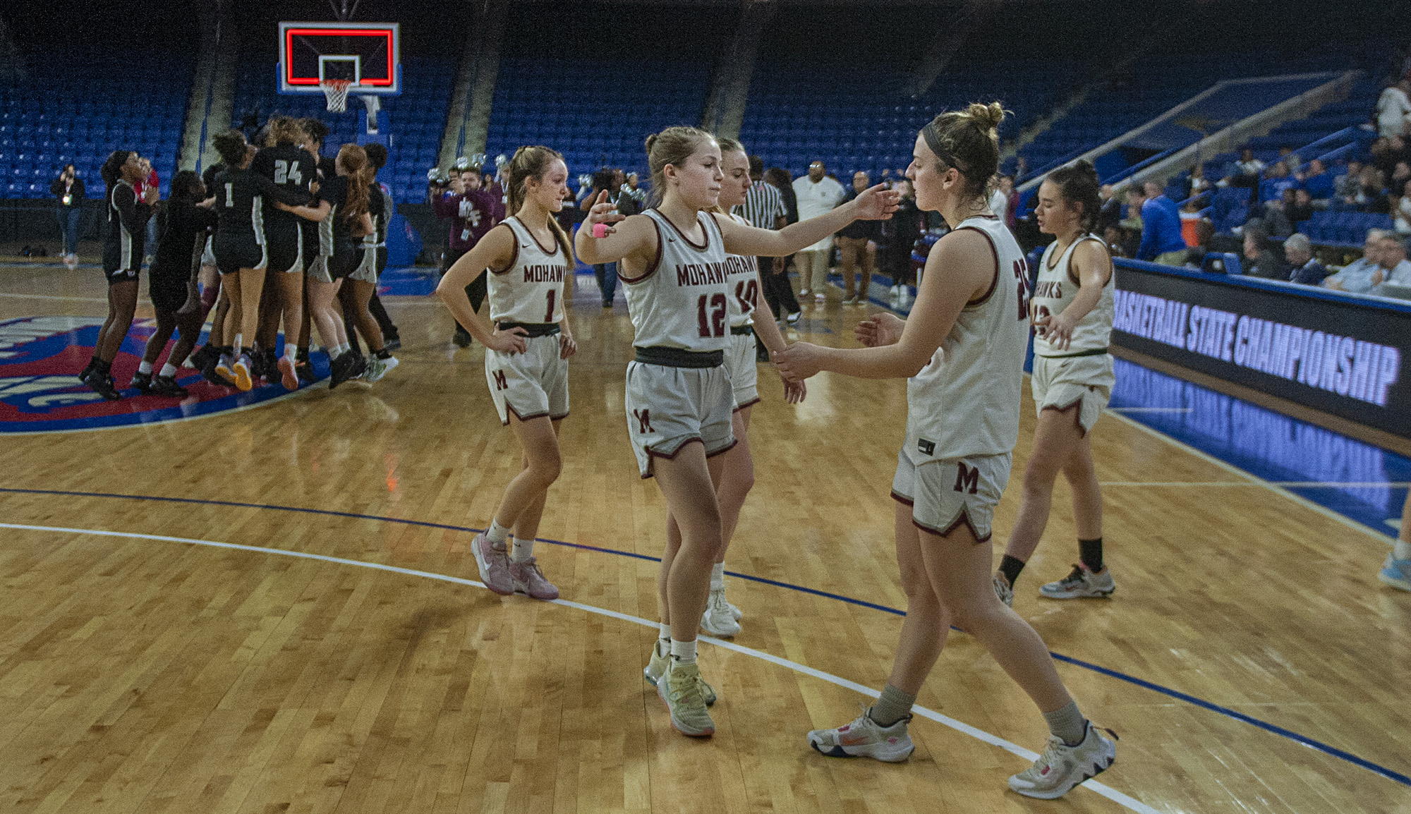The Millis High School girls basketball team, from left, Lindsey Grattan, Kyra Rice, Izzy Jewett, captain Mia Molinari, and captain Lily Avakian, react after losing to Springfield International Charter School, 42-34,  in the 2023 Div. 5 state finals at the Tsongas Center in Lowell, March 19, 2023. 