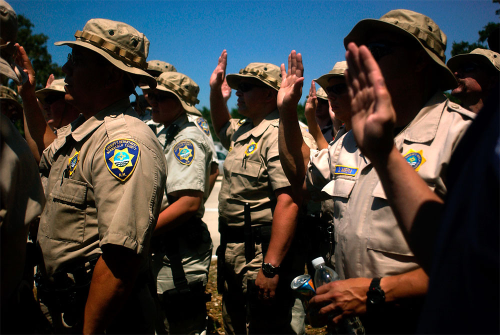 Bernalillo County Sheriff's Department deputies take an oath of office as they are deputized at a staging area in Gonzales, La. on Sept. 4. The group received an assignment to patrol a New Orleans neighborhood of which half was flooded.