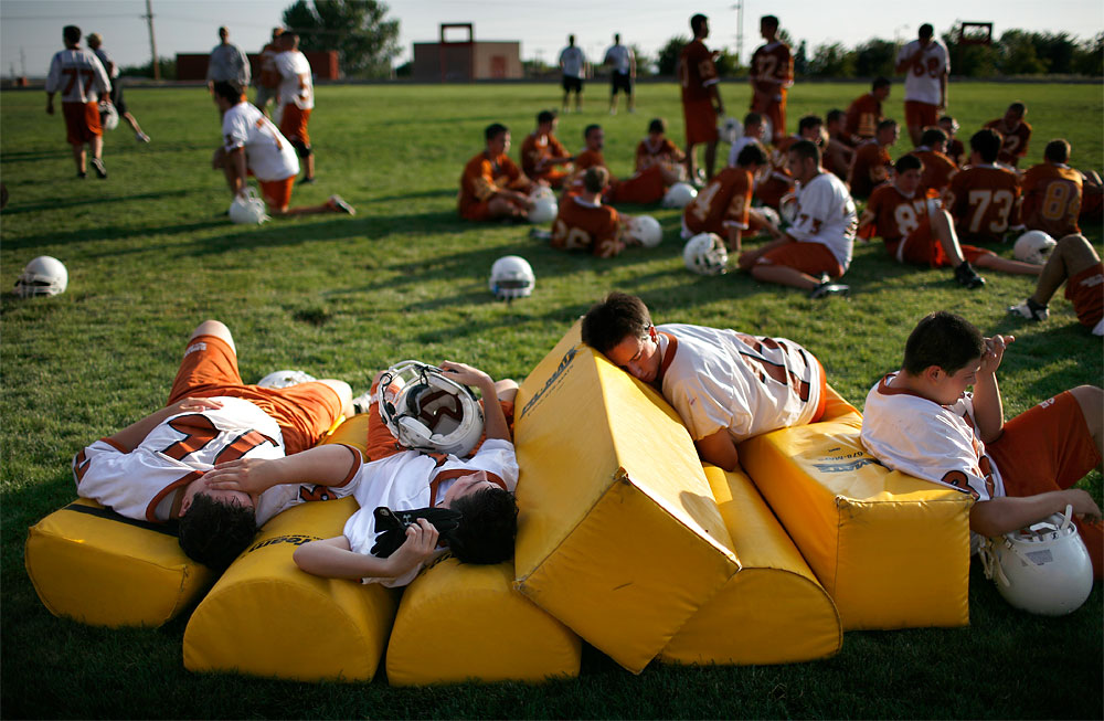 After narrowly completing a series of drills, members of Eldorado High School's football team collapse onto pads along the sideline. During the second day of practice and the first day of school classes. Charlie Dotson, Eldorado's new coach, quickly returned them to the practice field following a brief water break.