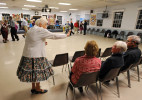 Vida Demale of Eastham who is celebrating her 87th birthday waves to a friend during the Nau-sets square dance at the Dennis Senior Center on Tuesday, March 4, 2014.