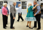 Vida Demale of Eastham hugs the caller Jim Shell of Lakeville as others lineup to thank him and bid him goodnight after an evening to fellowship. According to square dance etiquette, it's important to line up and formally show gratitude to the caller at the end of the night.