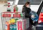 HYANNIS - A masked shopper loads up her minivan with supplies in the BJ’s Superstore parking lot on Monday, March 23, 2020. 