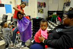 Evelyn Gray gives Audrey Nortey, 8, some corn rows with her son, Daniel Frempong, 1, at her side as Harriet Nortey and her daughter, Joelle, 8 months, watch at Evelyn's Braiding Shop on Thursday, April 23, 2015. 