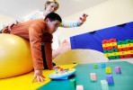 MASHPEE -- 03/28/11 -- Nickolas Qvarnstrom, 10, performs an upper body strength, coordination and balance exercise with his occupational therapist Madeline Langley at Cape Kids Therapy and Sensory Center. 